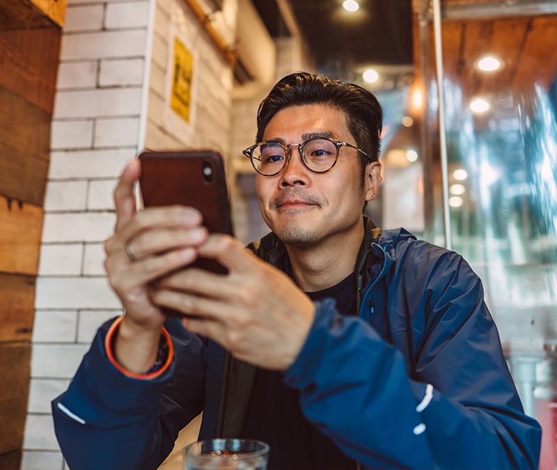 Un homme qui regarde fixement son téléphone.