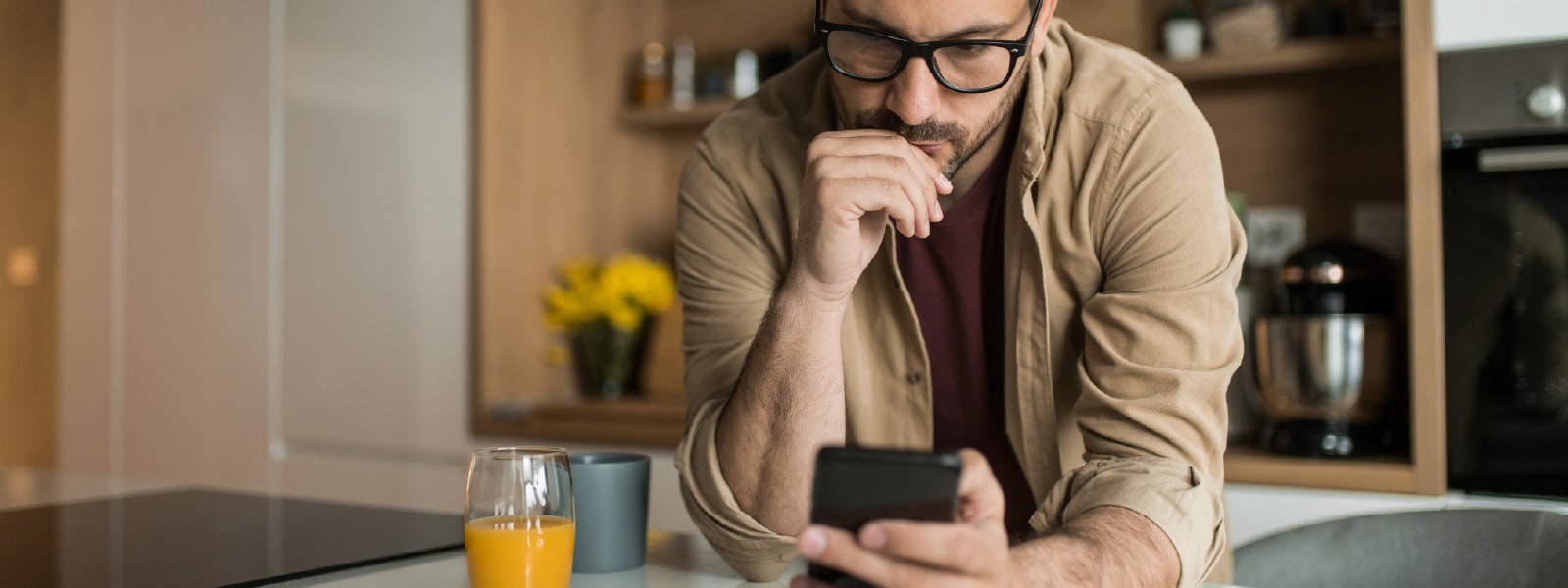 Un homme regardant son téléphone pour s’informer sur le clone phishing.