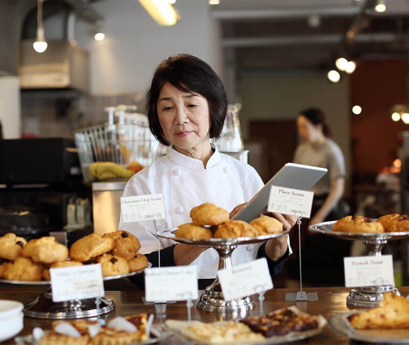 Le propriétaire d'une petite boulangerie fait l'inventaire des produits exposés.
