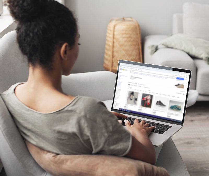 Une femme navigue sur eBay avec son ordinateur portable.