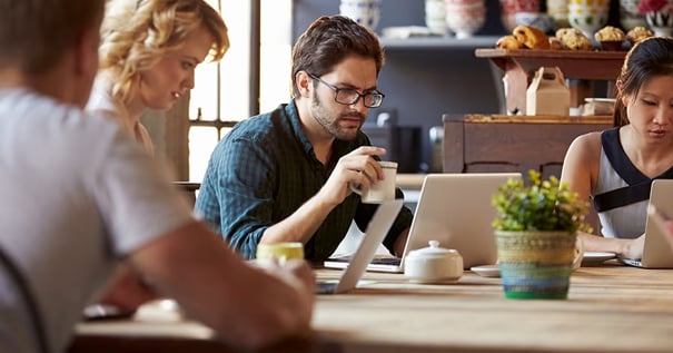 Personnes travaillant sur leur ordinateur portable dans un café pour illustrer le problème &laquo; Le Wi-Fi public est-il sécurisé ?