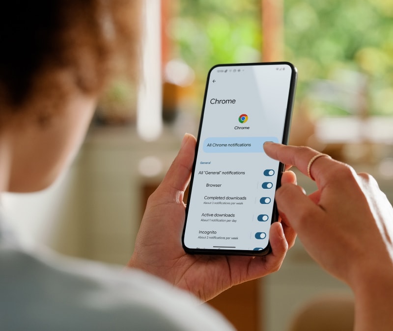 Une personne regardant les paramètres de son téléphone Android pour bloquer les fenêtres publicitaires indésirables.