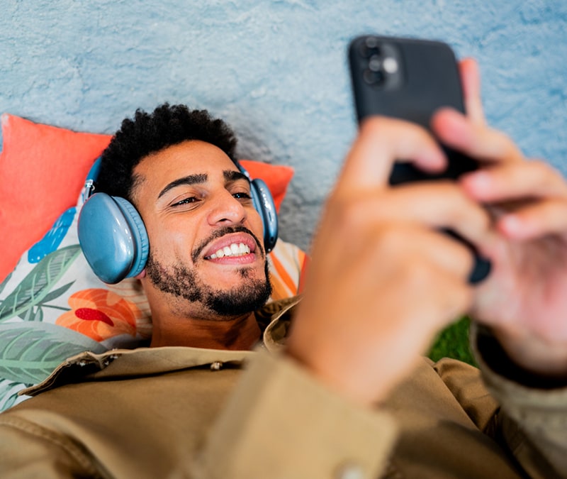 Un homme avec des écouteurs regarde son smartphone