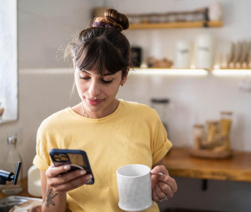 Une femme consulte les paramètres de son téléphone pour désactiver le microphone.