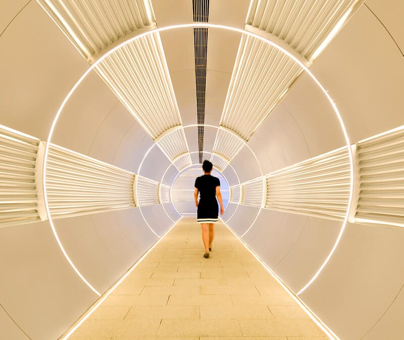 Une femme marche dans un tunnel pour représenter la segmentation de tunnel.