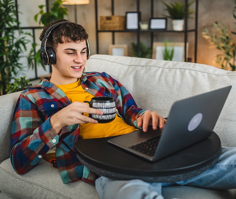 Une personne heureuse d'utiliser son ordinateur portable après avoir résolu un problème de connexion VPN.