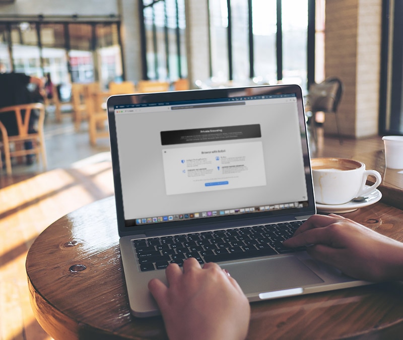 Une personne surfant en privé sur un Macbook Pro dans un café.