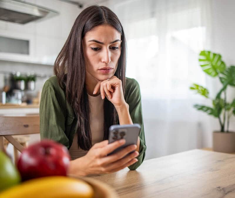 Image d'une personne frustrée regardant son téléphone