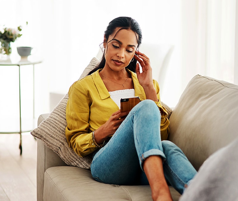 Une femme regarde son téléphone et se demande : « Mon téléphone a-t-il été piraté ? » 