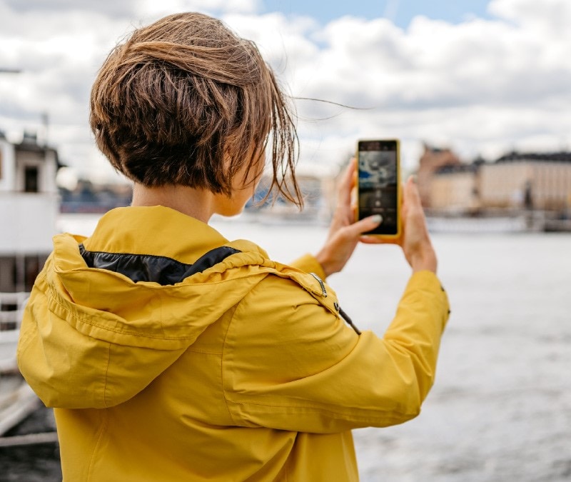 Une femme prend une photo, mais ignore que la caméra de son téléphone a été piratée.