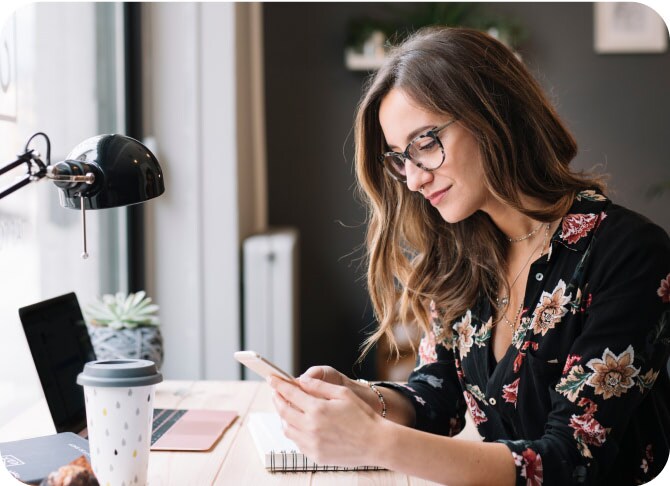 Femme dans son bureau consultant son téléphone