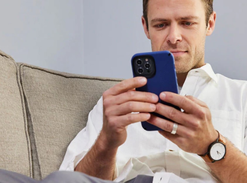 Homme sur un canapé regardant son téléphone