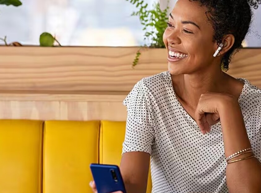 Femme assise rigolant au téléphone